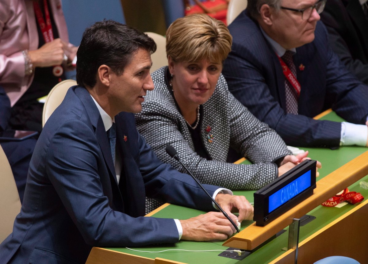 Prime Minister Justin Trudeau speaks with International Development Minister Marie-Claude Bibeau as they listen to speakers at the Nelson Mandela Peace Summit opening ceremony at the United Nations Headquarters, Monday, Sept. 24, 2018. 