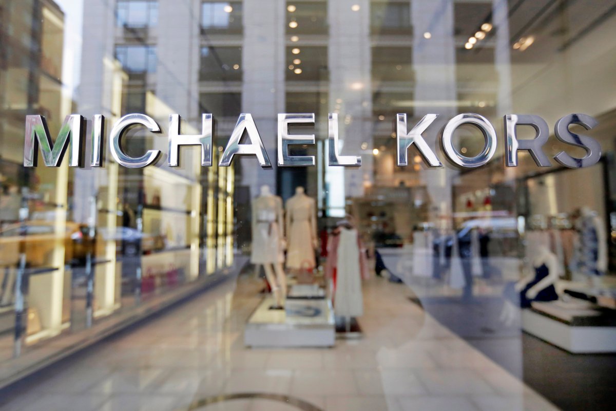 In this May 31, 2017, file photo the Michael Kors name adorns his store on Madison Avenue, in New York. Michael Kors is buying the Italian fashion house Gianni Versace in a deal worth more than $2 billion.