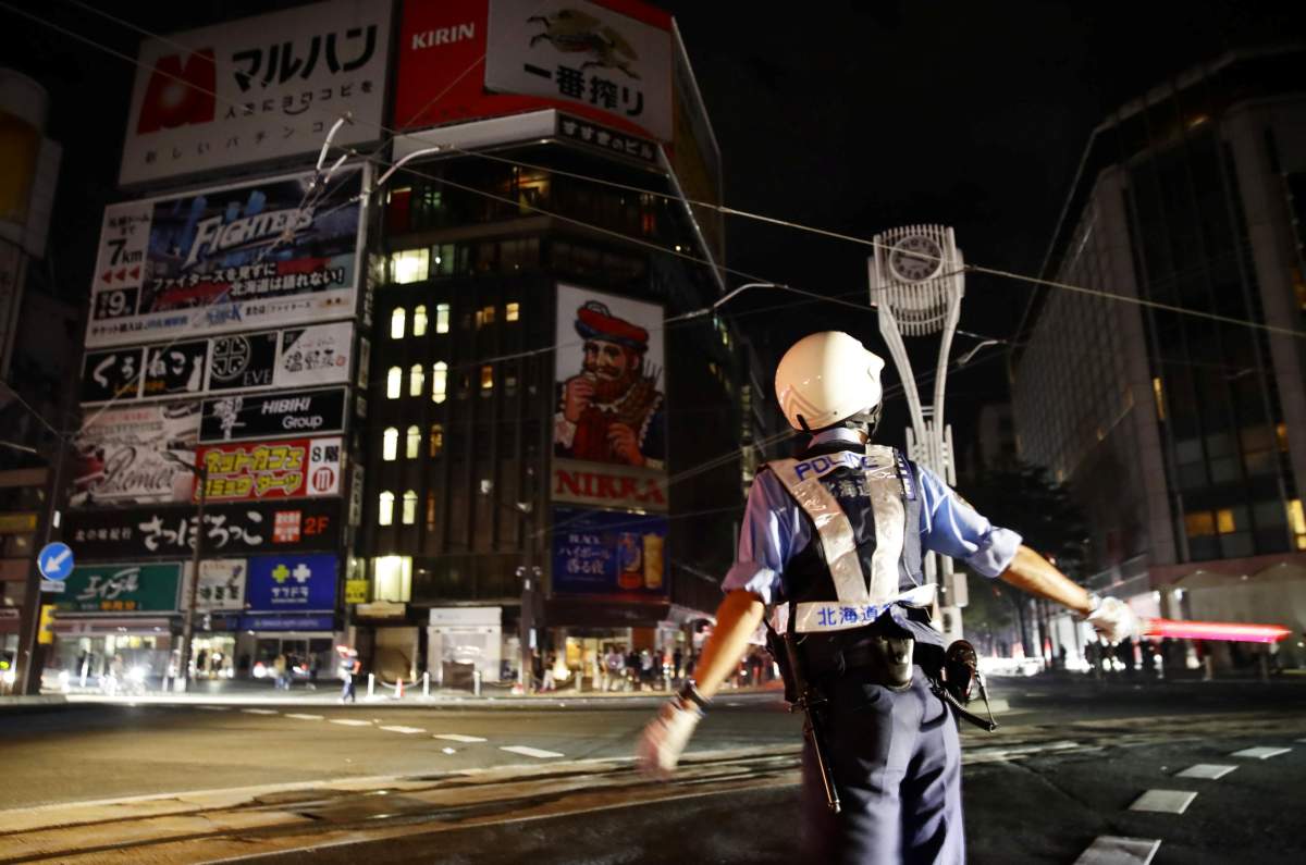 A police officer is seen during blackout after a powerful earthquake hit the area at a cross-point in Sapporo, Japan in this photo taken by Kyodo September 6, 2018.