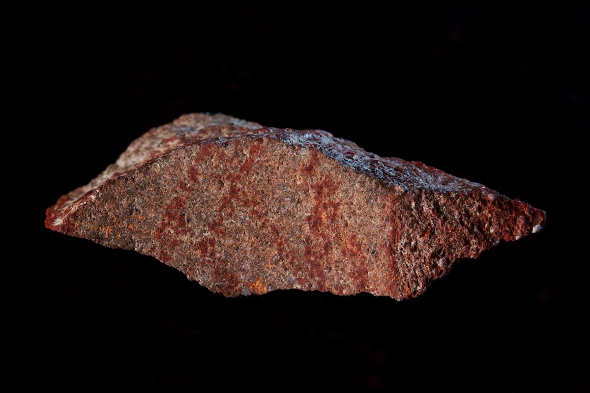 A stone flake discovered in Blombos Cave with red ochre markings that archeologists say represent one of the oldest-known examples of human drawings, on South Africa's southern coast is shown in this photo released September 12, 2018.