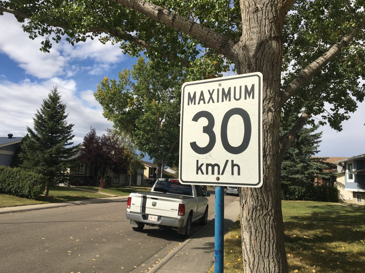 A speed limit sign on a residential street.