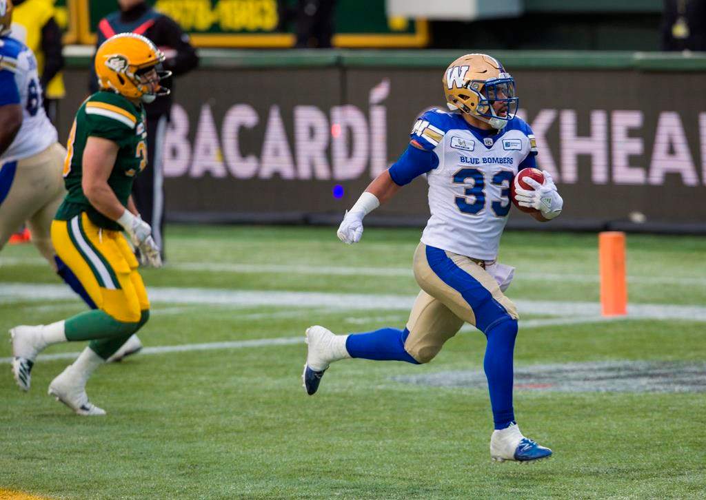 Winnipeg Blue Bombers' Andrew Harris (33) runs in a touchdown ahead of Edmonton Eskimos' Adam Konar (38) during first half CFL action in Edmonton, Alta., on Saturday September 29, 2018. THE CANADIAN PRESS/Amber Bracken.