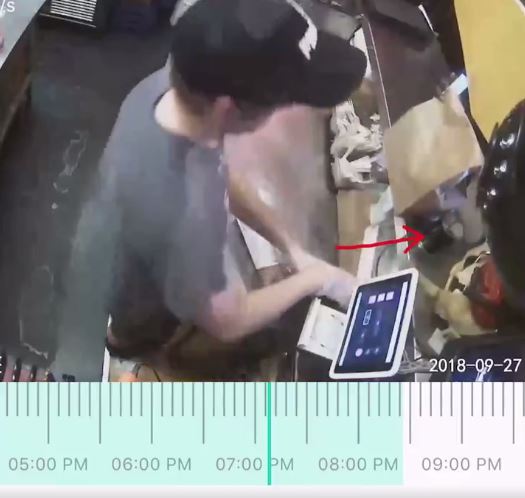 The security footage shows a person's hand reaching into the tip jar and swiping the money. 