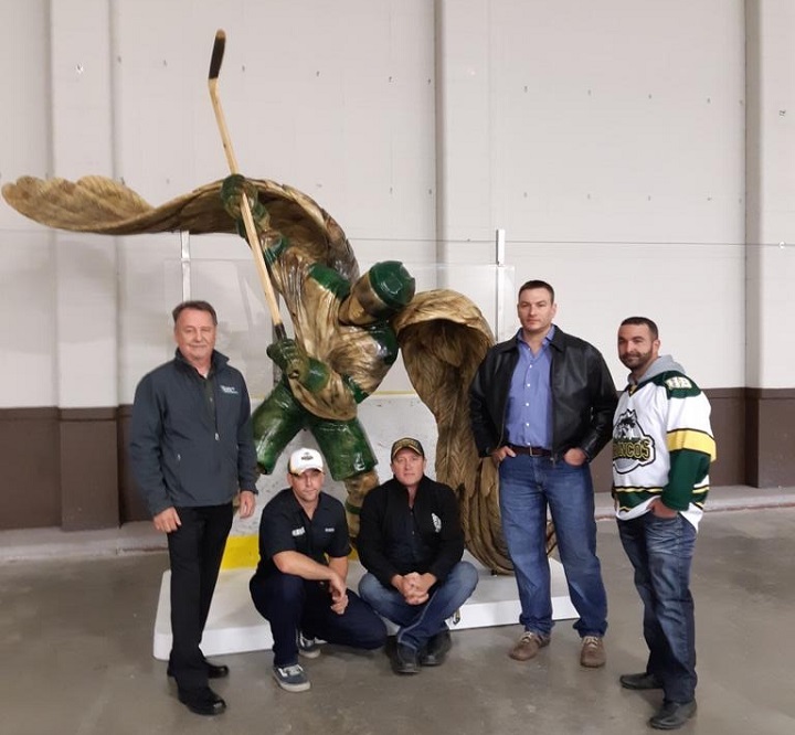Grant Hipfner, Shawn Eisenkrien, Geoff Stewart, Ryan Villiers and Mitch Boudreau with the sculpture they carved to honour the Humboldt Broncos.