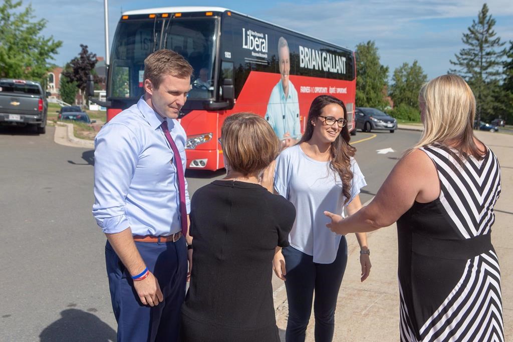 The New Brunswick Liberals are touting their party's plan to retain young people and draw expatriates back to the province. New Brunswick Liberal Leader Brian Gallant and wife Karine Lavoie, second from right, are greeted by candidates after arriving at a campaign stop in Fredericton on Wednesday, Sept. 5, 2018. THE CANADIAN PRESS/James West.