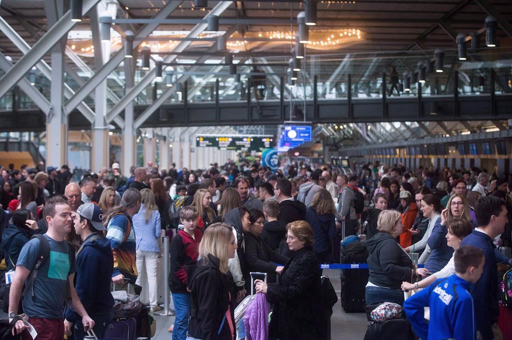 Hundreds of passengers wait in a lineup at Vancouver International Airport in Richmond, B.C., on Saturday April 1, 2017. A J.D. Power survey says Canada's three largest airports scored above the North American average by passengers. Vancouver International led, scoring 781 on a 1,000-point scale that measured satisfaction with check-in; food, beverage and retail; accessibility; terminal facilities and baggage claim.THE CANADIAN PRESS/Darryl Dyck.