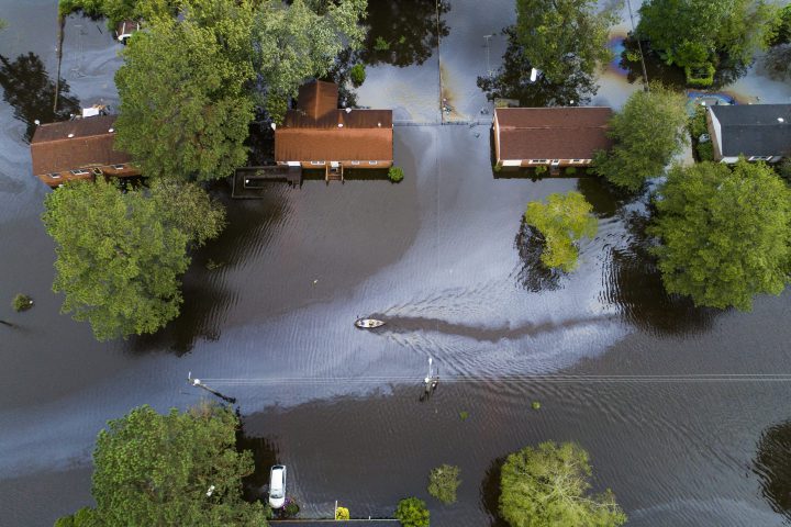 Two people in a canoe paddle through a street that was flooded by Hurricane Florence north of New Bern, N.C., on Sept. 15, 2018.
