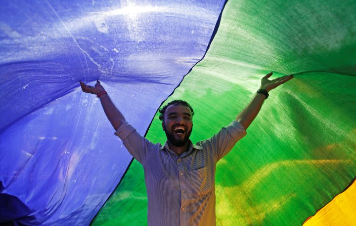 An LGBT supporter holds a rainbow flag as he celebrates a decision by India’s Supreme Court in Mumbai on Sept. 6, 2018.