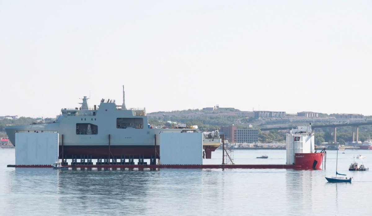 The Arctic and Offshore Patrol vessel HMCS Harry DeWolf rests on the launch deck of the Boabarge 37 in Halifax's Bedford Basin Saturday, Sept.15, 2018 as it begins the process of being floated by the submerging support vessel. 