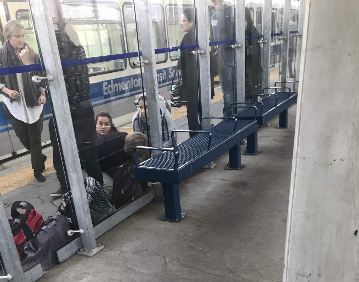 Bystanders helping an injured man at the South Campus LRT station in south Edmonton, Alta. on Tuesday, September 18, 2018.