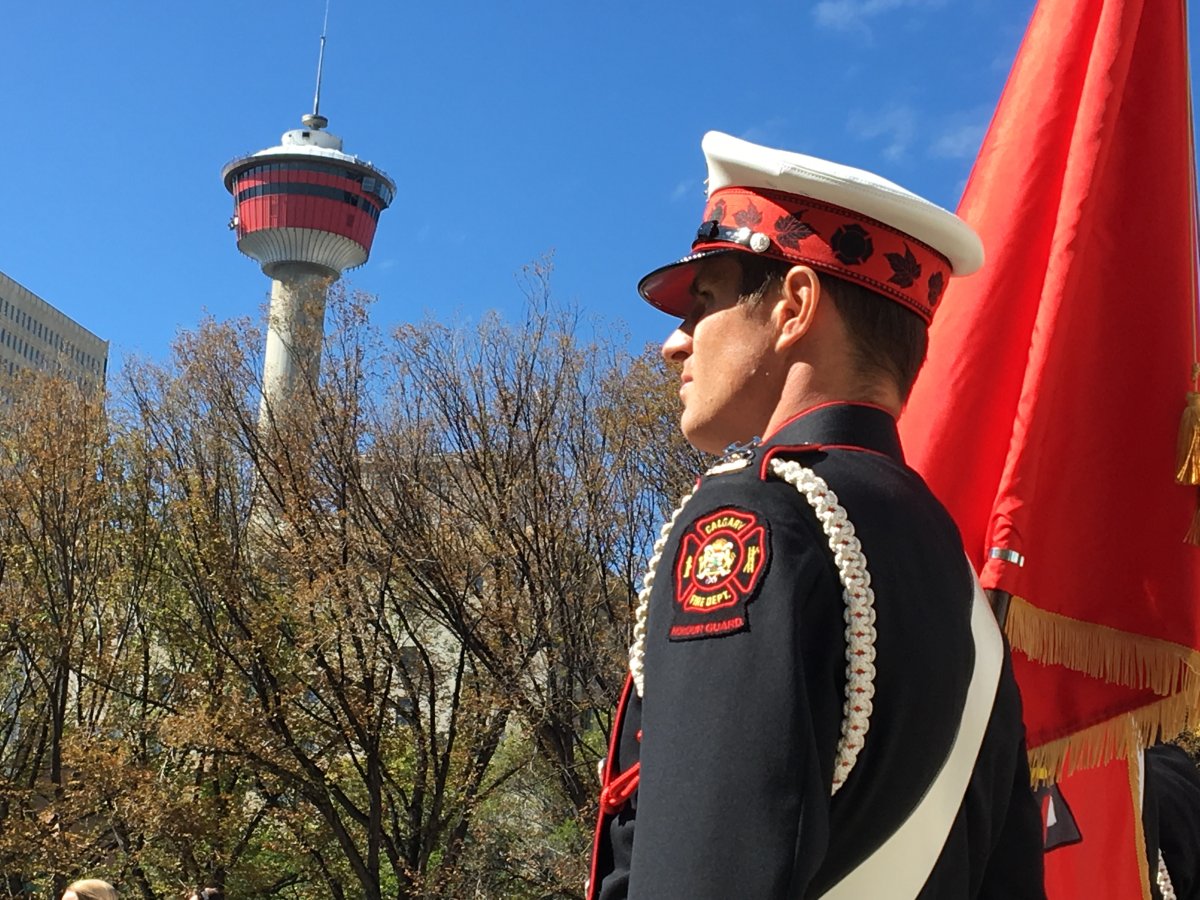 A Calgary firefighter stands at the firefighters memorial on Tuesday, Sept. 11. 