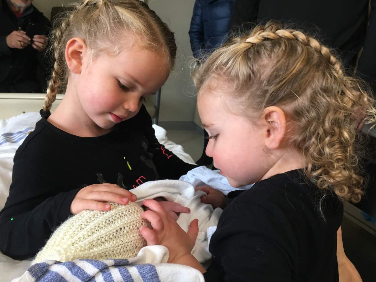 Big sisters Emanuelle and Amélie meeting baby brother Sidney