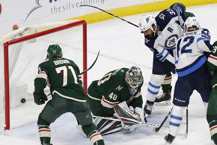 Winnipeg Jets defenceman Dustin Byfuglien (33) taps in a goal past Minnesota Wild goalie Devan Dubnyk and Wild right wing J.T. Brown (71) in the second period during a preseason NHL hockey game Wednesday, Sept. 26, 2018, in St. Paul, Minn. 