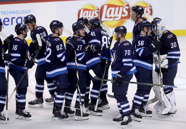 The Winnipeg Jets celebrate after defeating the Minnesota Wild during NHL preseason hockey in Winnipeg, Monday, September 17, 2018.