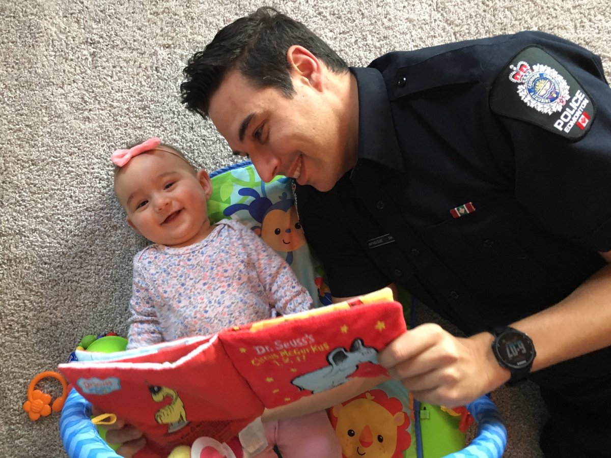 EPS Const. Mathieu Dube reads to his six-month-old daughter, Mirielle, ahead of Read In Week in Edmonton.