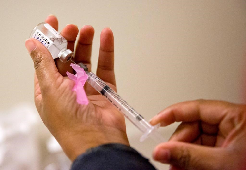 FILE - In this Feb. 7, 2018 file photo, a nurse prepares a flu shot at the Salvation Army in Atlanta.