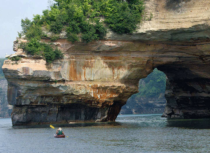 A kayaker is shown in Lake Superior off the cliffs at Pictured Rocks National Lakeshore near Munising, Mich. 