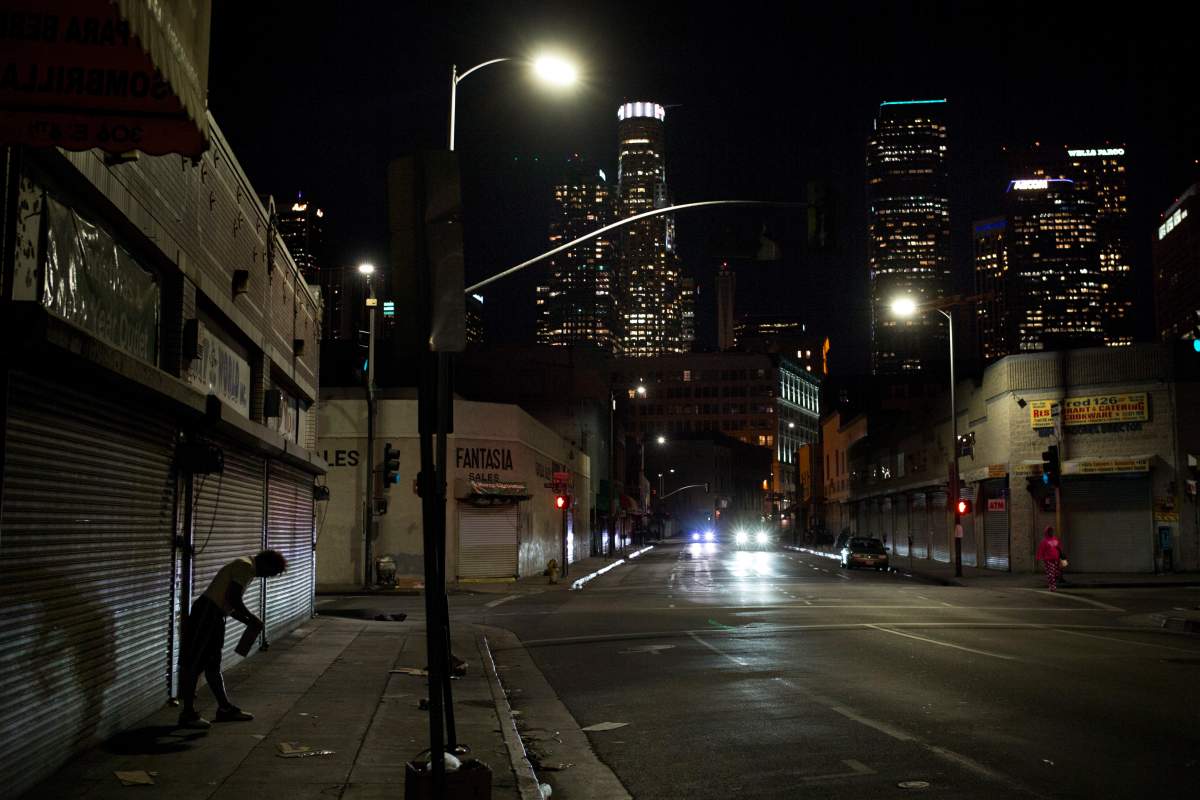 In this Nov. 7, 2017, file photo a homeless man wobbles back and forth tearing a cardboard box into pieces in the Skid Row area of downtown Los Angeles. 