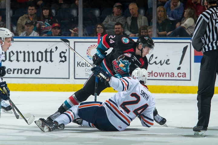 Luc Smith of the Kamloops Blazers, front, falls to the ice after a face-off against Kyle Topping of the Kelowna Rockets during WHL action at Prospera Place in Kelowna, B.C., on Saturday.