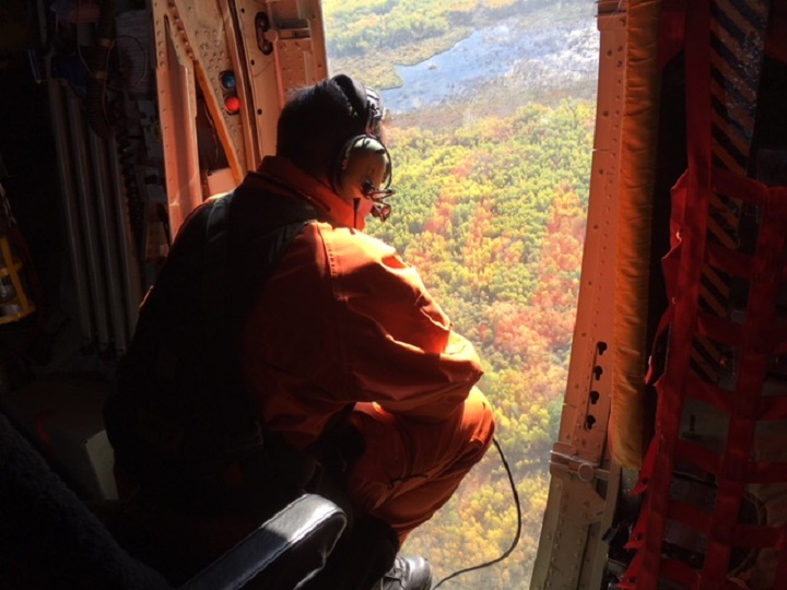 A member of the Search and Rescue team out of 17 Wing combs the landscape over Dauphin Thursday. Jordan Pearn/Global News