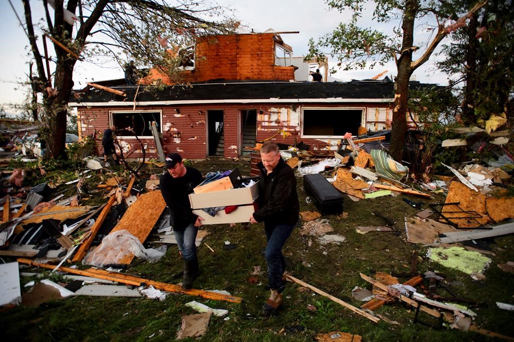 People collect personal effects from damaged homes following a tornado in Dunrobin, Ont., west of Ottawa on Friday, Sept. 21. Officials are warning people in the Ottawa area to brace for days without power in the wake of a tornado that ripped through the area.