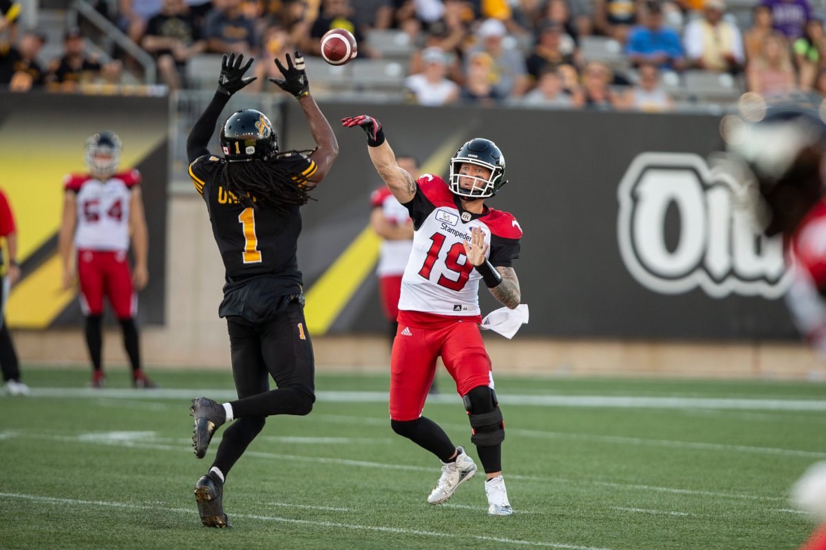 Calgary quarterback Bo Levi Mitchell tries to throw the ball past Hamilton's Don Unamba during third-quarter CFL action between the Ticats and the Stampeders in Hamilton, Ont., on Saturday, Sept. 15. 