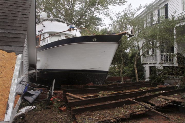A 40-foot yacht lies in the yard of a storm-damaged home on East Front Street in New Bern, N.C., Saturday, Sept. 15, 2018.