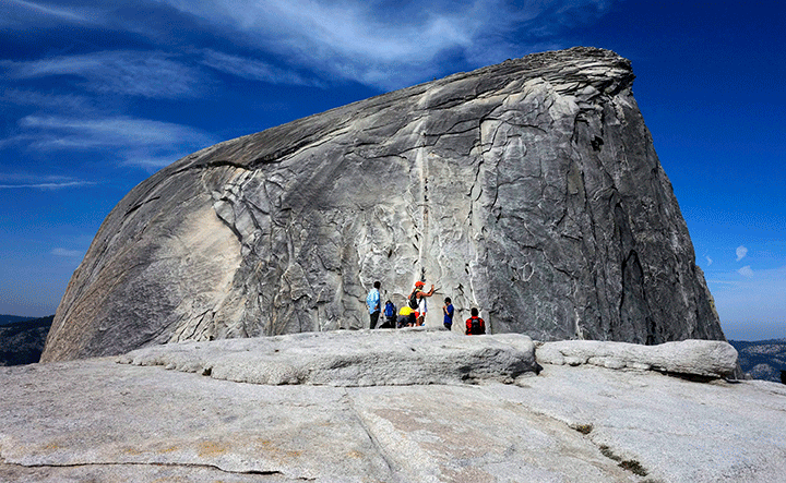 In this July 15, 2014 photo, hikers gather in the foreground as climbers use the assistance of cables to scale Half Dome in Yosemite National Park National Park in California.