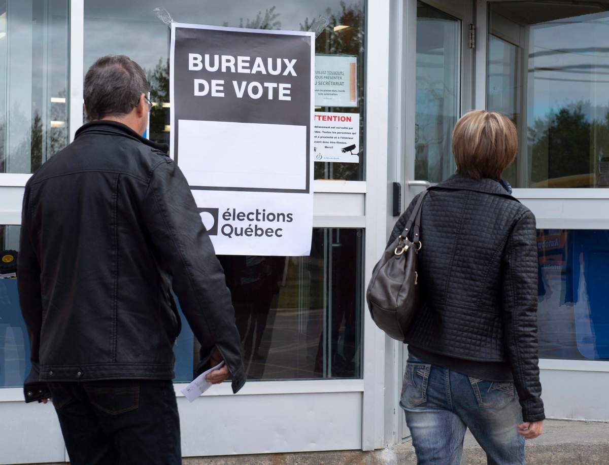 People walk to the polling station, Monday, October 1, 2018 in Saint-Felicien Que., as Quebecers are going to the polls in a general election.