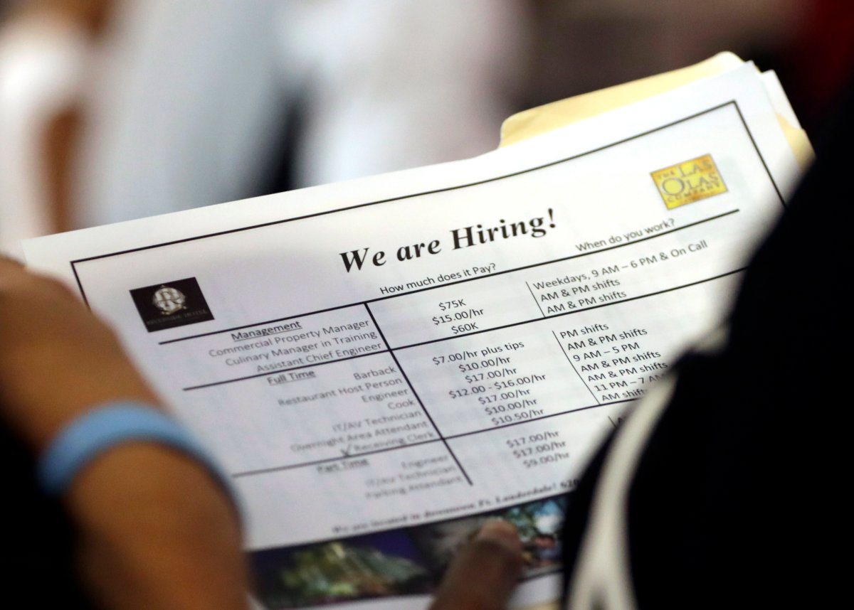 FILE - In this June 21, 2018 file photo, a job applicant looks at job listings for the Riverside Hotel at a job fair hosted by Job News South Florida, in Sunrise, Fla.