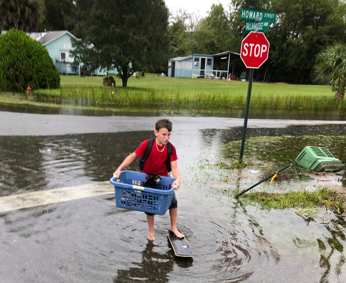 Jayden Morgan, 11, evacuates his home as water starts to flood his neighbourhood in St. Marks, Fla., ahead of Hurricane Michael. Gaining fury with every passing hour, Hurricane Michael closed in Wednesday on the Florida Panhandle with potentially catastrophic winds of 150 mph, the most powerful storm on record ever to menace the stretch of fishing towns, military bases and spring-break beaches. (AP Photo/Brendan Farrington)