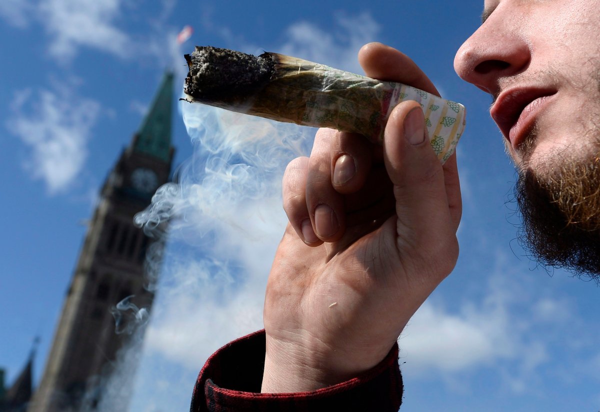 A man smokes a marijuana joint during the annual 4/20 marijuana celebration on Parliament Hill in Ottawa on Friday, April 20, 2018. 