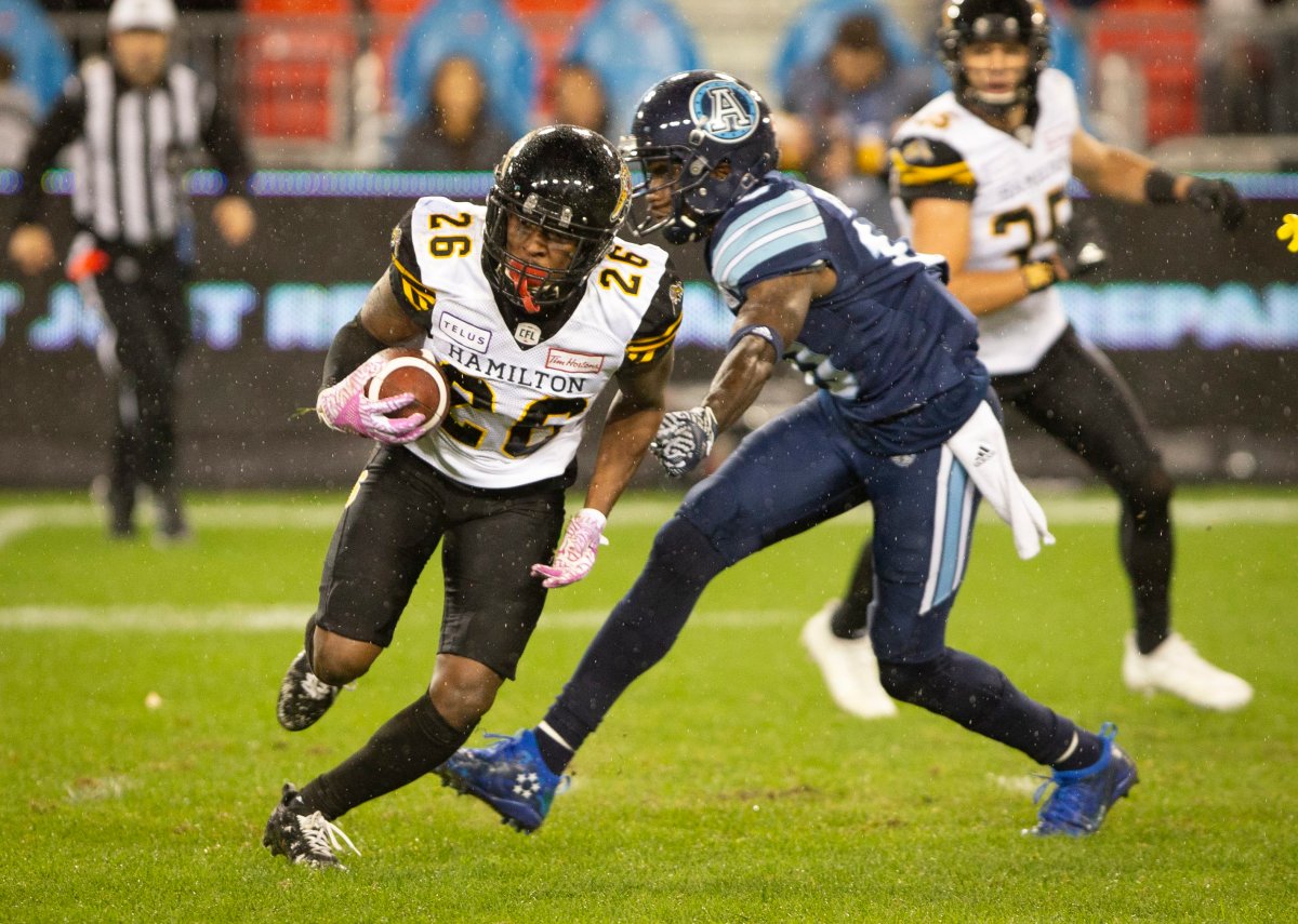 Hamilton Tiger-Cats defensive back Cariel Brooks (26) runs with the ball after making an interception during second half CFL action against the Toronto Argonauts in Toronto, on Friday, Oct. 12, 2018.  