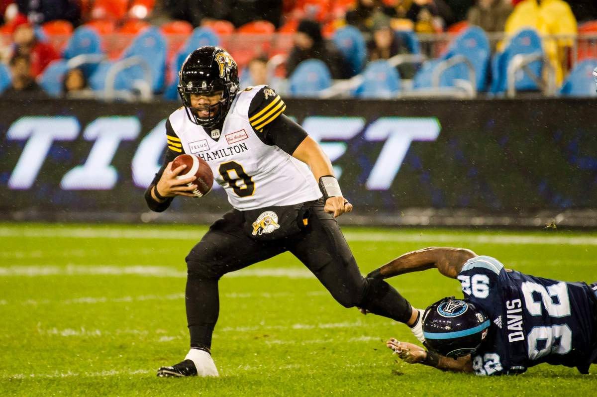 Hamilton Tiger-Cats quarterback Jeremiah Masoli (8) escapes a sack attempt by Toronto Argonauts defensive lineman Troy Davis (92) during second half CFL football action in Toronto on Friday, Oct. 12, 2018. 