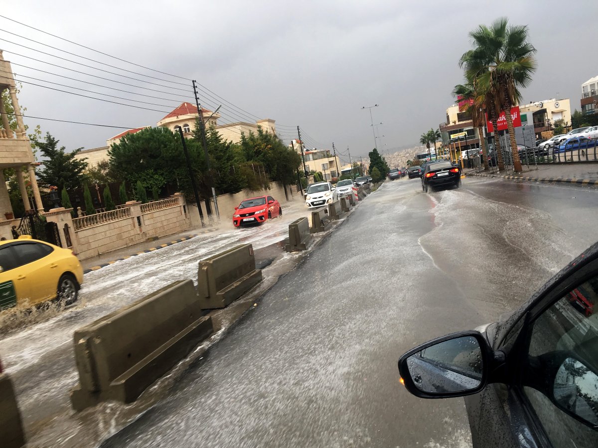 Vehicles wade through rain water after a sudden thunderstorm, at a street of Amman, Jordan, 25 October 2018.