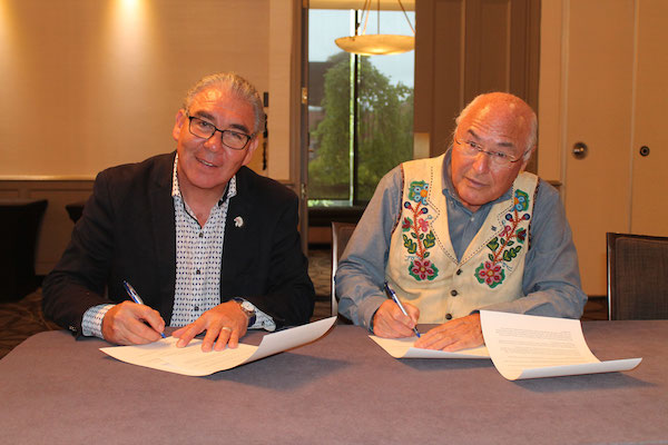 Chief Sidney Peters, co-chair of the Assembly of Nova Scotia Mi'kmaq Chiefs and Clement Chartier, President of the Metis National Council, sign a memorandum of understanding in Halifax.