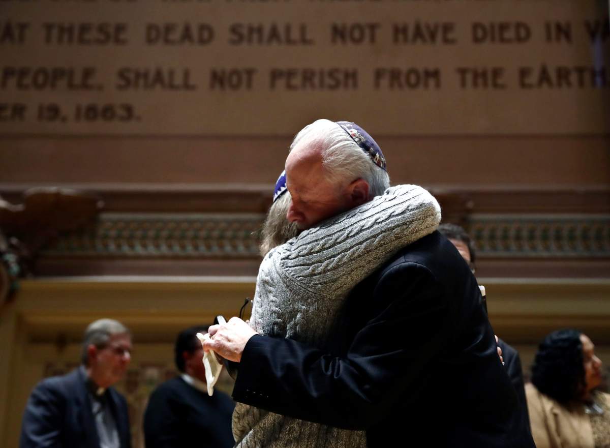 Rabbi Jeffrey Myers of Tree of Life/Or L’Simcha Congregation hugs Rabbi Cheryl Klein of Dor Hadash Congregation on the stage in Soldiers & Sailors Memorial Hall & Museum during a community gathering held in the aftermath of a deadly shooting at the Tree of Life Synagogue in Pittsburgh, Sunday, Oct. 28, 2018.