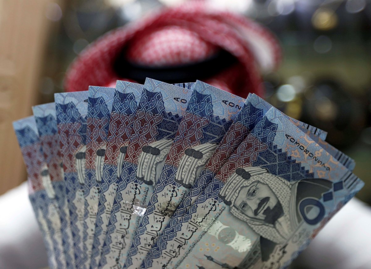 FILE PHOTO: A Saudi money changer displays Saudi Riyal banknotes at a currency exchange shop in Riyadh, Saudi Arabia July 27, 2017.
