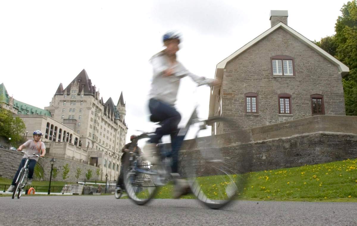 Cyclists ride by the Bytown Museum (right) that sits below the Chateau Laurier Hotel in downtown Ottawa, Thursday May 22, 2008.