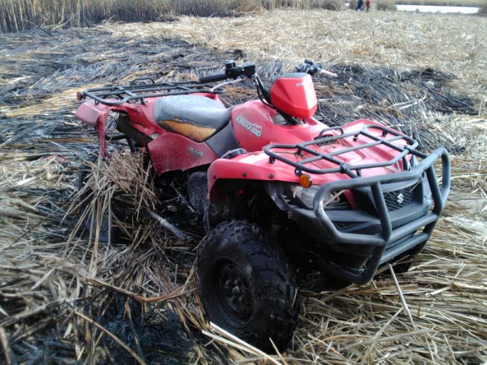 A charred ATV at the scene of a marsh fire that spread about one kilometre and threatened a nearby oil and propane business.