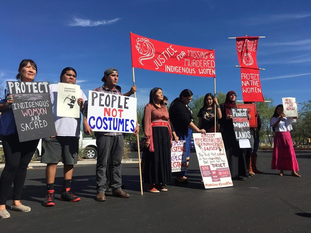 Native American protesters stand outside the Phoenix office of Yandy.com, a retailer of "sexy Native American" costumes on Wednesday, Oct. 24, 2018.
