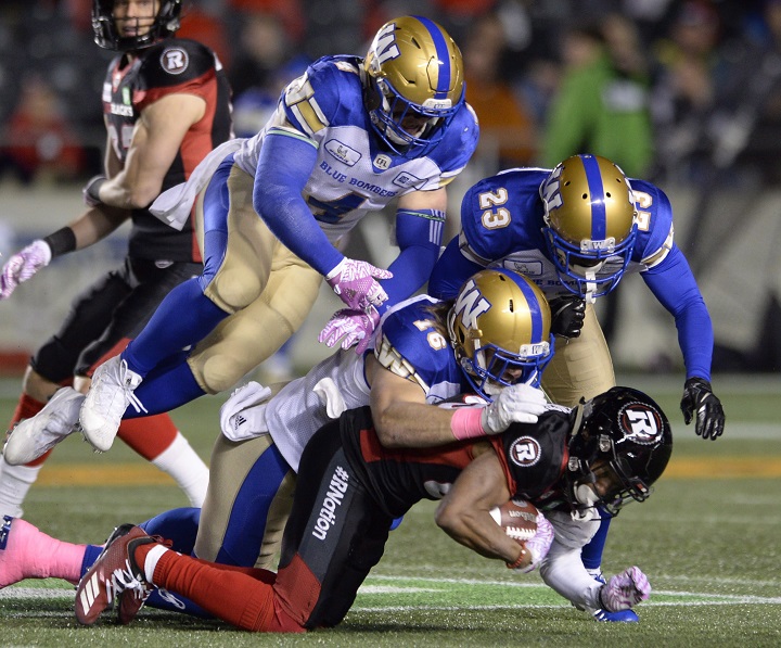 Winnipeg Blue Bombers defensive back Taylor Loffler (16), linebacker Adam Bighill (4) and defensive back Anthony Gaitor (23) bring down Ottawa Redblacks wide receiver Diontae Spencer during first half CFL football action in Ottawa on Friday, Oct. 5, 2018. 
