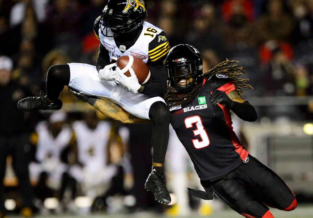 Hamilton Tiger-Cats wide receiver Brandon Banks (16) makes a catch as Ottawa Redblacks defensive back Rico Murray (3) tackles during second-half CFL action in Ottawa on Friday, Oct. 19, 2018.