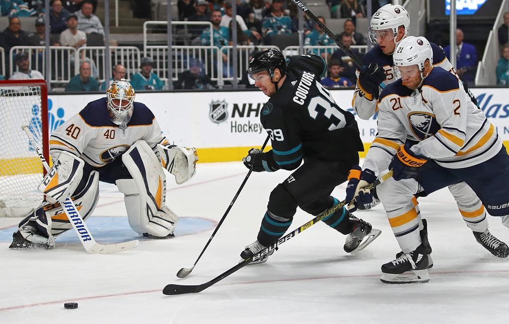 San Jose Sharks' Logan Couture (39) moves the puck against Buffalo Sabres' Rasmus Ristolainen (55) and Kyle Okposo, right, in the third period of an NHL hockey game Thursday, Oct. 18, 2018, in San Jose, Calif.