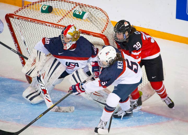 Canada's Emily Clark tries to get a shot past team United States' Molly Schaus during the gold medal game of the Four Nations Cup women's hockey tournament on Nov. 8, 2014.