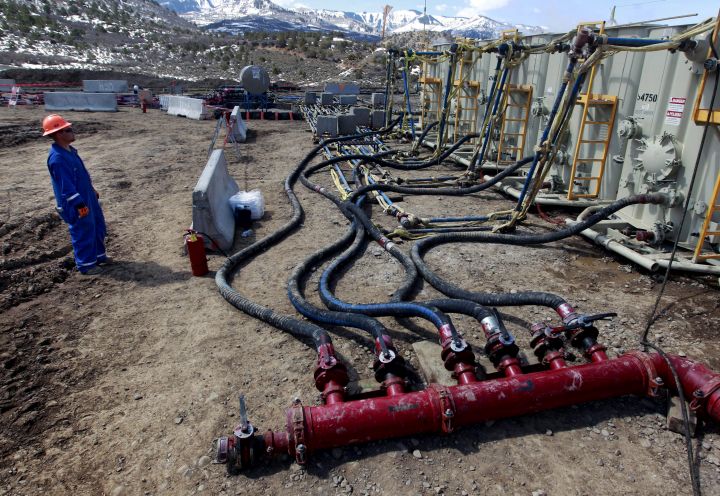 In this March 29, 2013 file photo, a worker helps monitor water pumping pressure and temperature at a hydraulic fracturing and extraction site in Western Slope of Colorado.