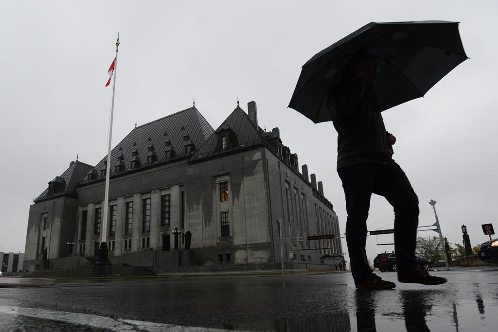 FILE - A man walks pass the Supreme Court of Canada in Ottawa on Thursday, Nov. 2, 2017.