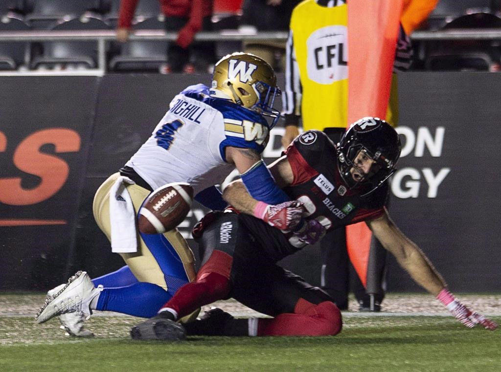 Winnipeg Blue Bombers linebacker Adam Bighill (4) knocks the ball loose from Ottawa Redblacks wide receiver Brad Sinopoli during overtime CFL action in Ottawa on Friday, Oct. 5, 2018. THE CANADIAN PRESS/Adrian Wyld