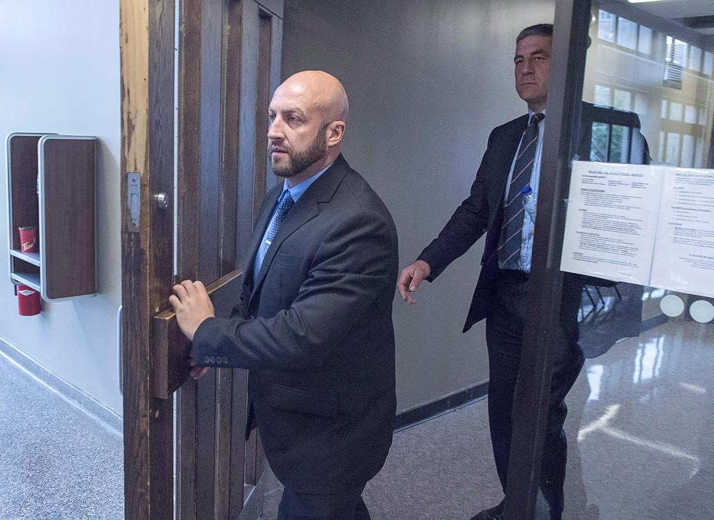 Darren Smalley, left, a British sailor charged with sexual assault causing bodily harm, heads from Supreme Court in Halifax on September 4, 2018.