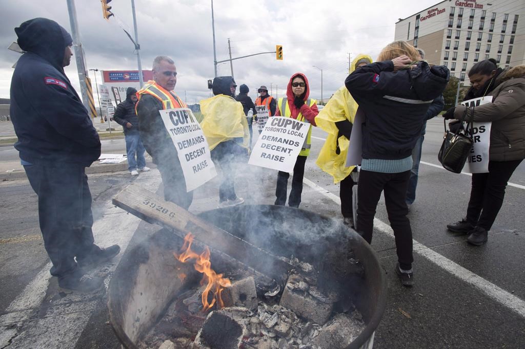 Striking Canada Post workers walk the picket line in Mississauga, Ontario on Tuesday, October 23, 2018.